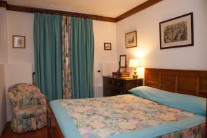 a bedroom with a bed and a chair at Casa Das Obras in Manteigas +61 photos