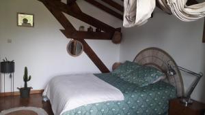 a bedroom with a bed with a green comforter at Maison Florenchaenia sur le Chemin de Compostelle in Saint-Jean-Pied-de-Port