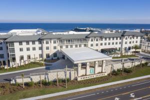 un gran edificio blanco al lado de una carretera en Embassy Suites St Augustine Beach Oceanfront Resort, en St. Augustine Beach