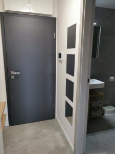 a bathroom with a black door and a sink at Apartmán v Jizerkách in Janov nad Nisou