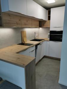 una cocina con armarios blancos y encimeras de madera en Apartmán v Jizerkách, en Janov nad Nisou