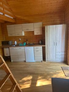 a kitchen with white cabinets and a refrigerator at Domki Międzyzdroje in Międzyzdroje