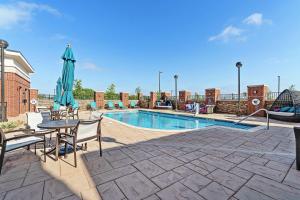 a pool with a table and chairs and an umbrella at Hilton Garden Inn Edmond/Oklahoma City North in Edmond