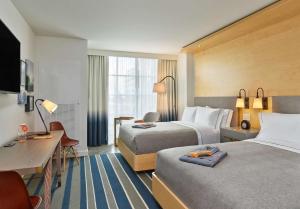 um quarto de hotel com duas camas e uma secretária em Canopy By Hilton Washington DC Bethesda North em North Bethesda