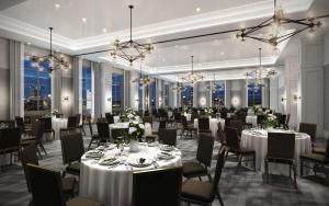 un salón de banquetes con mesas y sillas blancas y ventanas en Canopy By Hilton Washington DC Bethesda North, en North Bethesda