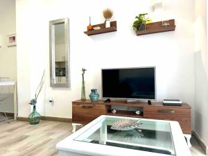 sala de estar con TV y mesa de cristal en Apartamento en Aguadulce sur, en Aguadulce