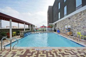 une piscine en face d'un bâtiment dans l'établissement Home2 Suites by Hilton Brownsville, à Brownsville