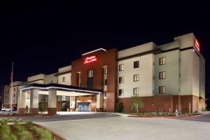 薩克拉門托的住宿－Hampton Inn & Suites Sacramento at CSUS，上面有灯的标志的酒店大楼