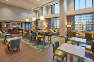 um restaurante com mesas e cadeiras e um bar em Hampton Inn & Suites Sacramento at CSUS em Sacramento