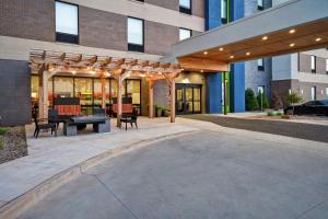 a patio with a table and chairs in front of a building at Home2 Suites By Hilton Oklahoma City Airport in Oklahoma City