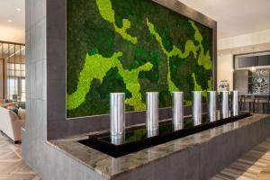 a large green wall in the lobby of a building at Embassy Suites By Hilton San Antonio Landmark in San Antonio