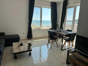 25m FROM THE BEACH!! Luxury Sea Paradise Apartment في كافارنا: غرفة معيشة مع طاولة وكراسي والمحيط