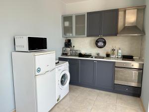 a kitchen with a refrigerator and a washer and dryer at First Line On The Beach Cosy Sea Paradise Apartments in Kavarna