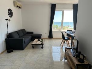 a living room with a couch and a table at First Line On The Beach Cosy Sea Paradise Apartments in Kavarna