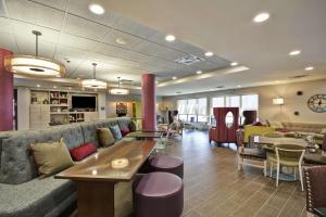 a lobby with a couch and a table and chairs at Home2 Suites by Hilton KCI Airport in Kansas City