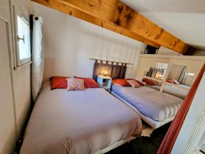 dwa łóżka są w pokoju z dwoma w obiekcie Villa à deux pas de la plage Richelieu w Cap d'Agde