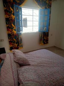 um quarto com uma cama em frente a uma janela em Villa Mama Swiriya Atlantique em Souira Guedima