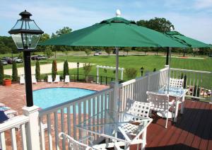 a deck with a table and a green umbrella at Virginia Crossings Hotel, Tapestry Collection by Hilton in Richmond