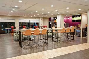 a restaurant with tables and chairs in a cafeteria at Home2 Suites by Hilton Atlanta Norcross in Norcross