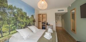 a bedroom with a white bed with a large window at Hôtel et Cottages Domaine Du Marquenterre in Saint-Quentin-en-Tourmont