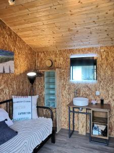 um quarto com uma cama e um lavatório num quarto em Entre terre et mer em Sainte-Eulalie-en-Born