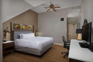 a hotel room with a bed and a desk and a television at Virginia Crossings Hotel, Tapestry Collection by Hilton in Richmond