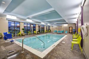 una piscina en una habitación de hotel con sillas y mesas en Home2 Suites By Hilton Columbus Airport East Broad en Columbus