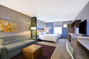Habitación de hotel con cama y sofá en Home2 Suites By Hilton Columbus Airport East Broad, en Columbus