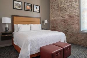 a bedroom with a large bed and a brick wall at Hampton Inn Petaluma, Ca in Petaluma