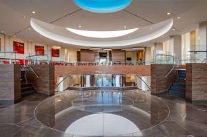 a lobby with a table in the middle of a building at Hilton Garden Inn Dallas At Hurst Conference Center in Hurst