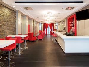 a restaurant with red chairs and a bar at DORMERO Schlosshotel Reichenschwand in Reichenschwand