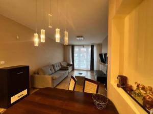 a kitchen and living room with a table and a couch at Apartament Nuldenovski Resort Grzybowo in Grzybowo