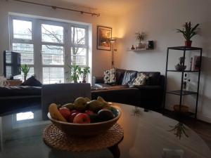 a living room with a bowl of fruit on a table at Bright, modern apartment in Grand Canal Dock in Dublin