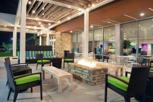 un patio con una hoguera, mesas y sillas en Home2 Suites By Hilton Indianapolis Greenwood en Indianápolis