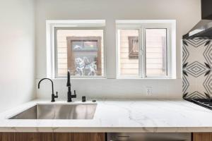 a white kitchen with a sink and two windows at Beach Home W AC- 5 BR - Free Parking - EV Charge in San Diego