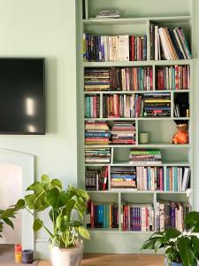 una estantería llena de libros en la sala de estar en Home in Chiswick Homefields en Londres