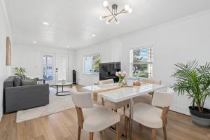 a dining room with a white table and chairs at ALKI Retreat! Steps-2-BEACH - PARKING in Seattle