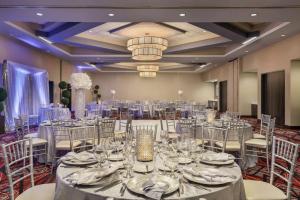 una sala de banquetes con mesas, sillas y una lámpara de araña en Embassy Suites By Hilton Noblesville Indianapolis Conv Ctr, en Noblesville