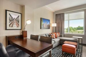 a living room with a couch and a table at Embassy Suites By Hilton Noblesville Indianapolis Conv Ctr in Noblesville