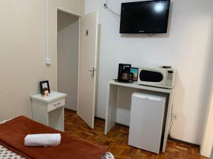 a small room with a microwave and a small table with a microwave at Flórida in São Carlos