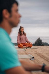 a man and a woman sitting on the floor in meditation at El Gato Gordo - bike & surf house in Cudillero