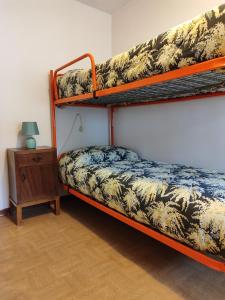 a bedroom with two bunk beds and a night stand at Alloggio Matrimoniale vicino Asiago (Roana) in Roana