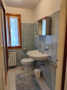uma casa de banho com um lavatório e um WC em Alloggio Matrimoniale vicino Asiago (Roana) em Roana