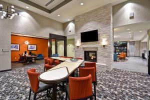 a lobby with a fireplace and tables and chairs at Homewood Suites By Hilton Rocky Mount in Rocky Mount