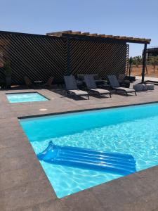una piscina con agua azul y sillas en Hotel Partana, en Ensenada