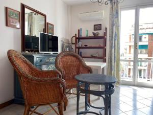 a living room with two chairs and a table and a television at Casa Ribot: Alassio centro e mare a portata di mano in Alassio