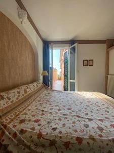 a bedroom with a large bed with a floral bedspread at Casa Ribot: Alassio centro e mare a portata di mano in Alassio