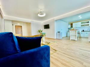 a living room with a blue couch and a kitchen at Residence Odaile #2 in Otopeni