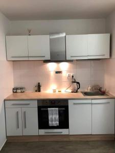 a kitchen with white cabinets and a stove top oven at Spí v Kuklenách in Hradec Králové