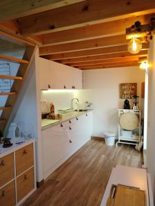 a kitchen with white cabinets and wooden ceilings at I Loft Viana in Viana do Castelo